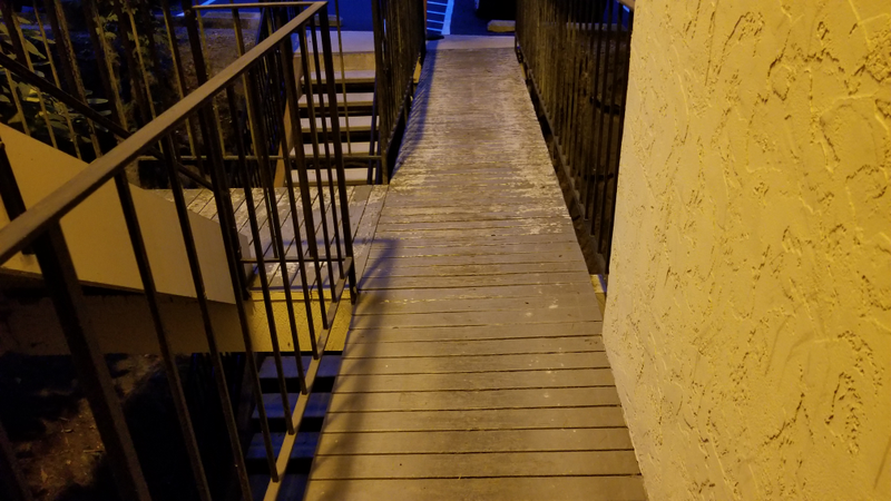 See the white crap down the walkway? Yeah? That’s the paint. It’s all supposed to be white. The grey sections are bare wood, and they’re starting to sag inward because of water retention. The whole walkway was replaced two years ago if you can believe it.